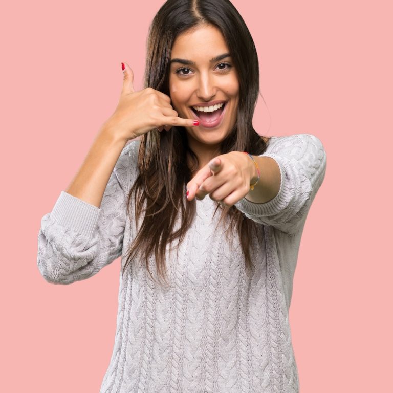 Young hispanic brunette woman making phone gesture and pointing front over isolated background